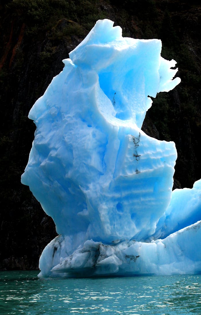 Mastering the First Impression: Your intriguing post title goes here Stunning blue iceberg against a rugged backdrop in a serene natural setting.